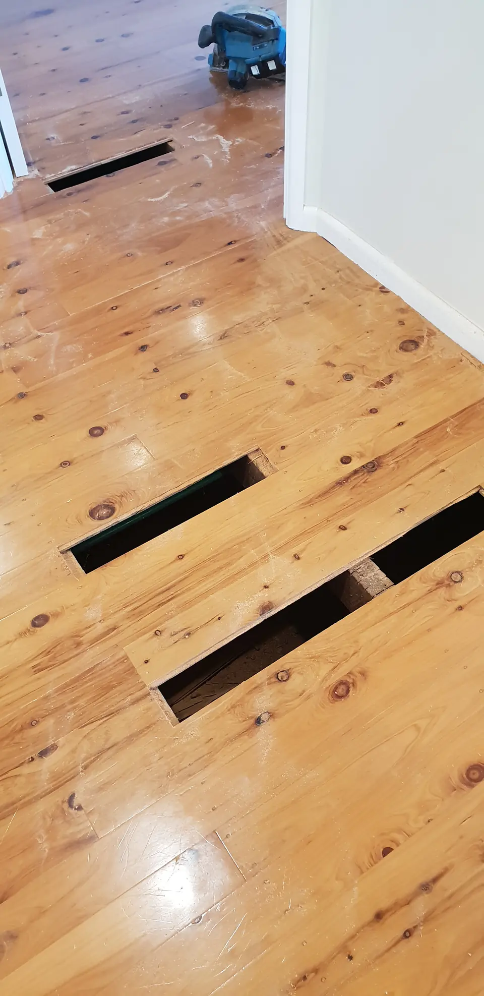 Timber floorboards with visible gaps and exposed sections during repair work